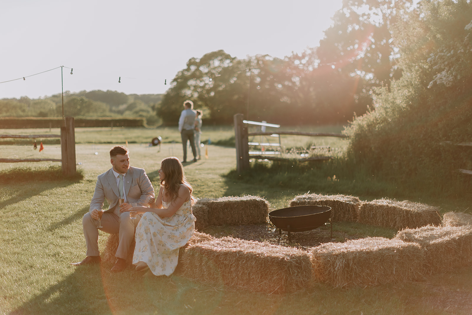 Wedding guests relaxing on the lawn by the fire pit at The Secret Barn.